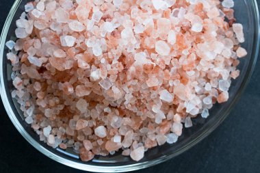 Karanlık bir arka plan üzerinde pembe Himalaya deniz tuzu