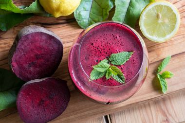 Ahşap arka plan üzerinde bir bardak kırmızı pancar suyu