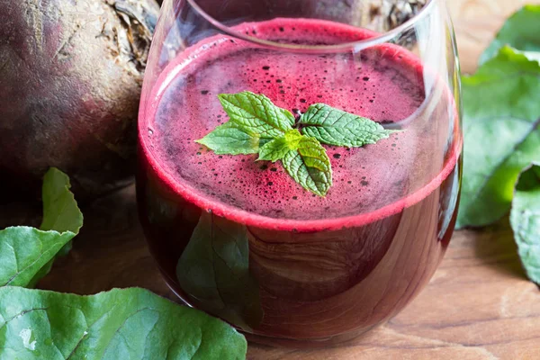 Succo di barbabietola rossa in un bicchiere su uno sfondo di legno — Foto Stock