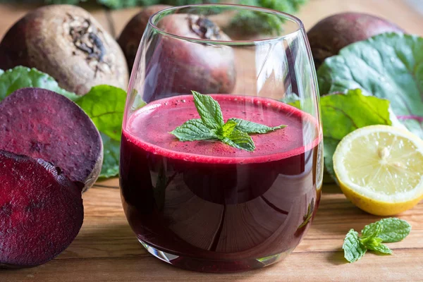 Succo di barbabietola rossa in un bicchiere su uno sfondo di legno — Foto Stock