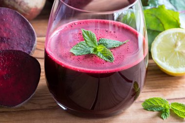 Kırmızı pancar suyu bir bardak limon ve pancar yeşillikleri ile