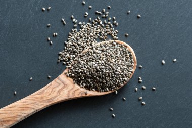 Chia tohum üzerinde karanlık bir arka plan üzerine bir tahta kaşık