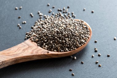 Chia tohum üzerinde karanlık bir arka plan üzerine bir tahta kaşık