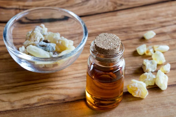 A bottle of frankincense essential oil with frankincense crystal — Stock Photo, Image