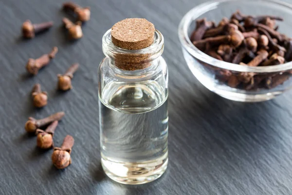 Een fles van kruidnagel etherische olie met gedroogde teentjes — Stockfoto