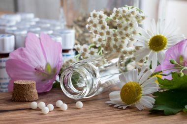 Homeopatik globüller otlar ve çiçeklerle bir şişe