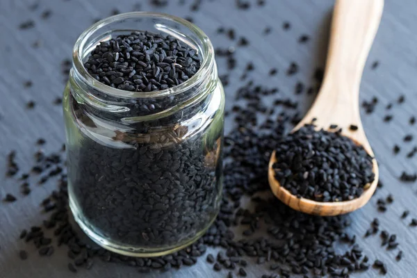 Black cumin seeds in a glass jar — Stock Photo, Image