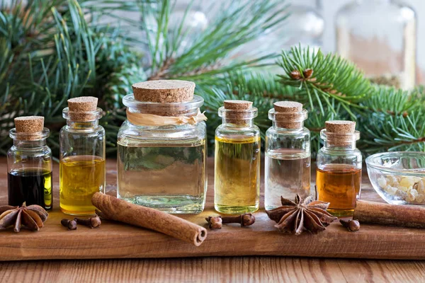 Selection of essential oils with Christmas spices and branches