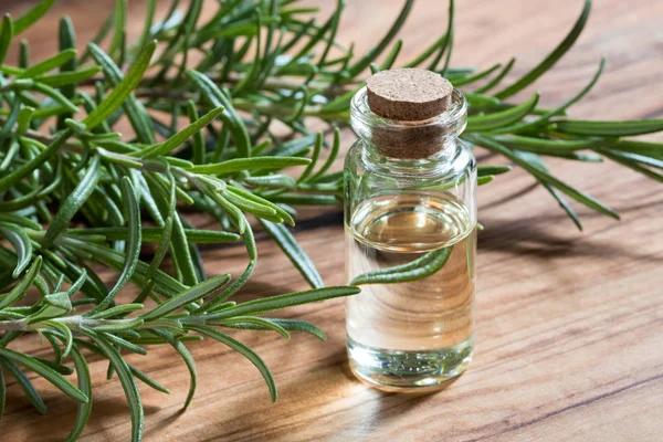 Una botella de aceite esencial de romero con romero fresco — Foto de Stock