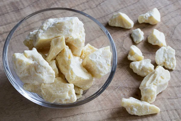 Stukken van cacaoboter in een glazen kom — Stockfoto