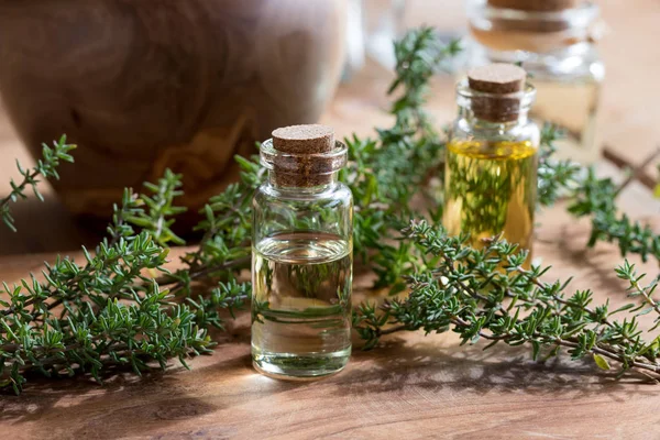 Een fles van essentiële tijmolie met takjes verse tijm — Stockfoto