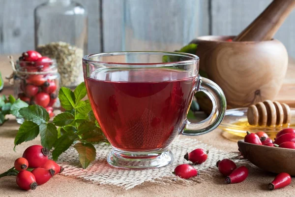 Una taza de té rosa mosqueta con rosa mosqueta fresca — Foto de Stock