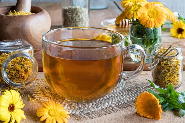 Чашка чаю календули з квітами календули на фоні — стокове фото