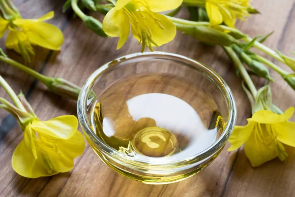 Evening primrose oil in a glass bowl on a dark background — Stock Photo, Image