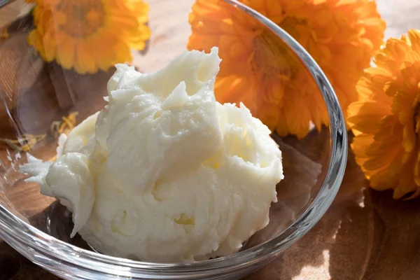 Crème Calendula in een glazen kom, met goudsbloem bloemen in de b — Stockfoto