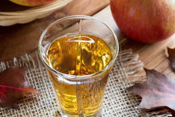 Un vaso de vinagre de manzana sobre una mesa de madera — Foto de Stock