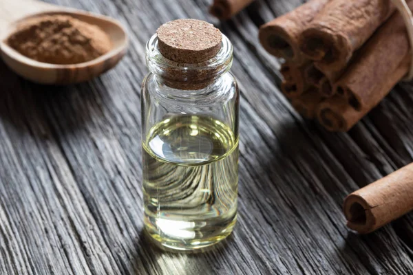 Een fles van kaneel etherische olie op oud hout — Stockfoto