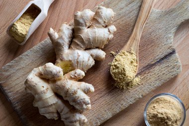 Taze zencefil kökü ve zemin ahşap kesme tahtası üzerinde zencefil