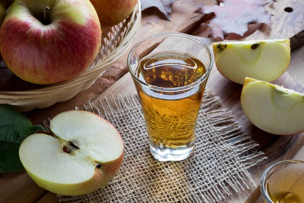 Æblecidereddike i et glas, med æbler i baggrunden - Stock-foto