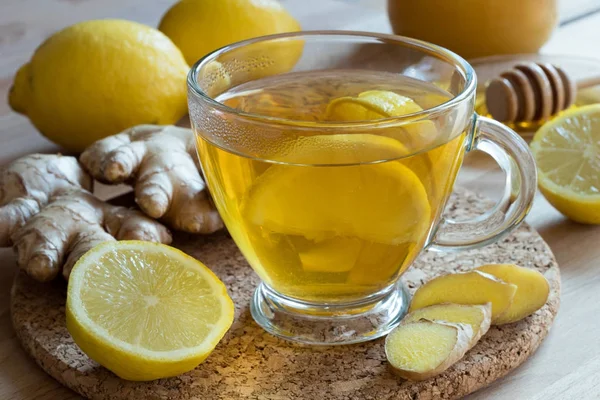 Zencefil çayı ile limon, bal ve arka planda taze zencefil