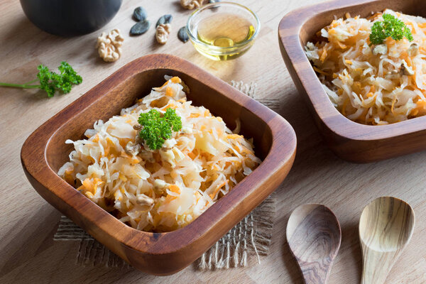 Fermented cabbage and carrots in two wooden bowls