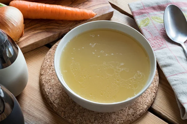 Caldo de osso de frango em um boliche de sopa em uma mesa — Fotografia de Stock