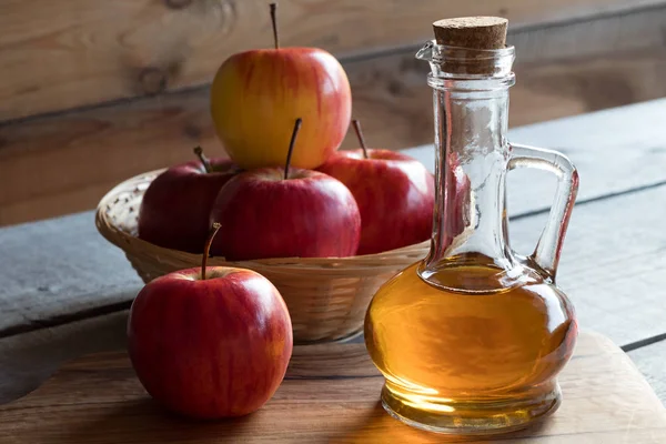 Una botella de vinagre de manzana con manzanas — Foto de Stock