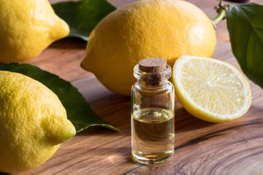 Bir şişe limon uçucu yağ ile backgro içinde taze limon
