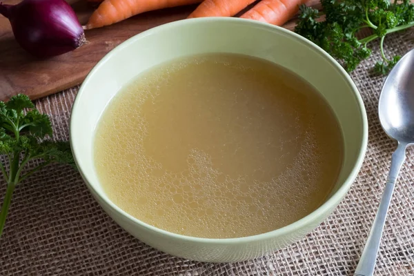 Caldo de osso de frango em uma tigela de sopa verde — Fotografia de Stock