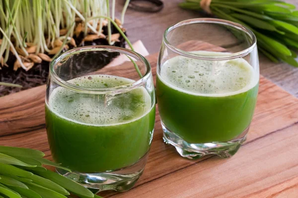 Two glasses of barley grass juice with fresh barley grass in the — Stock Photo, Image