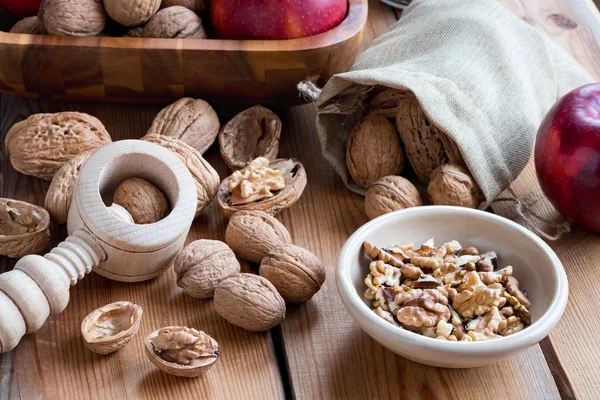 Оболочки и необработанные грецкие орехи на деревянном столе — стоковое фото
