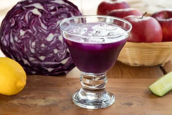 Paarse kool SAP in een glas op een houten tafel — Stockfoto