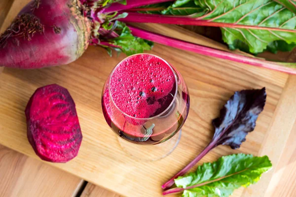 Jugo de remolacha roja en una copa de vino sobre una mesa de madera — Foto de Stock