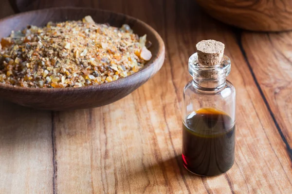 Бутылка эфирного масла с миррой на деревянной вкладке — стоковое фото