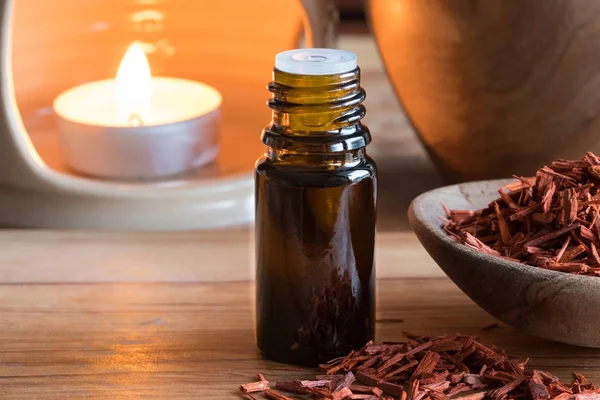 A bottle of sandalwood essential oil with sandalwood — Stock Photo, Image