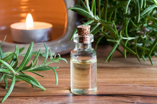 A bottle of rosemary essential oil with fresh rosemary twigs — Stock Photo, Image