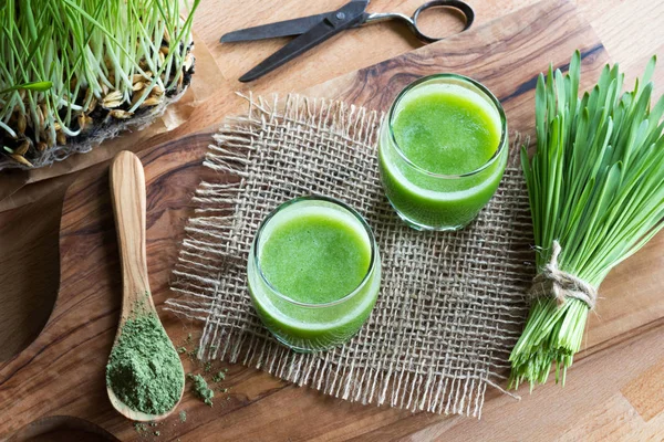 Zwei Gläser grünen Safts mit frisch geerntetem Gerstengras — Stockfoto