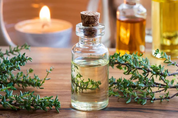 Sebuah botol transparan thyme minyak esensial dengan thyme twi segar — Stok Foto