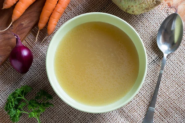 Bot kippenbouillon in een groene soep kom, bovenaanzicht — Stockfoto