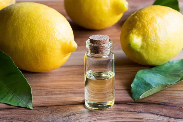 Bir şişe limon uçucu yağ taze limon ve yaprakları ile