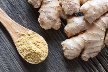 Zemin zencefil ve ahşap arka plan üzerinde taze zencefil kökü