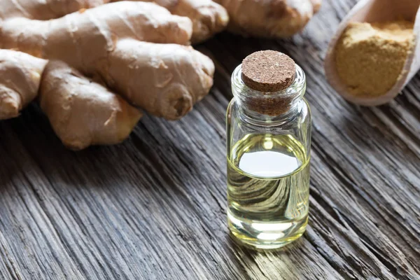 Eine Flasche ätherisches Ingweröl mit frischem und getrocknetem Ingwer — Stockfoto