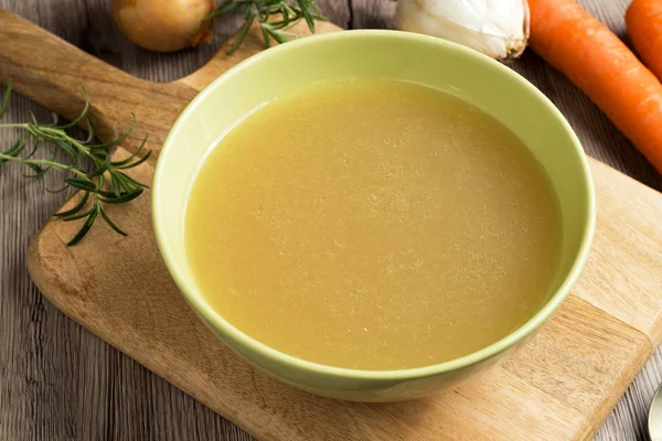 Caldo de osso de frango em uma tigela de sopa verde — Fotografia de Stock