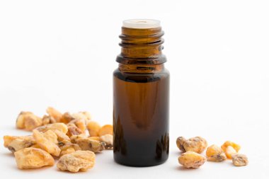 A bottle of styrax benzoin essential oil with benzoin resin clipart