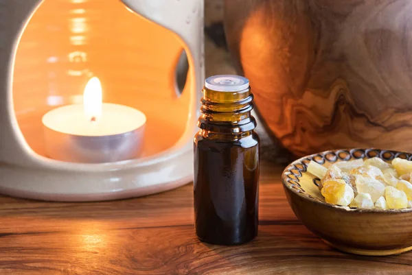 A dark bottle of frankincense essential oil with frankincense re — Stock Photo, Image