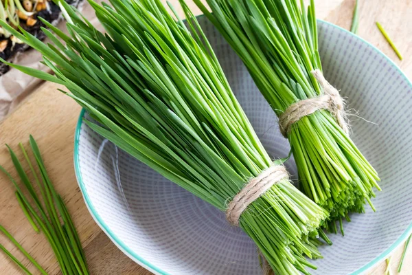 Frisch geerntetes Weizengras in einer Schüssel auf einem Tisch — Stockfoto