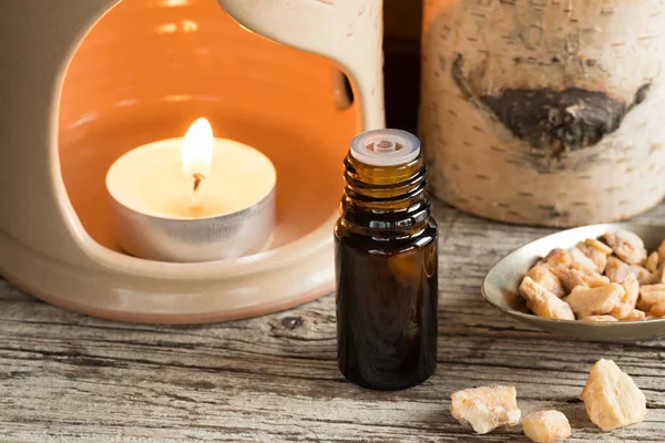 A bottle of styrax benzoin essential oil with an aroma lamp — Stock Photo, Image