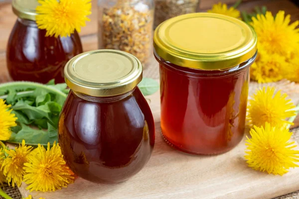 Mælkebøtte honning i glas krukker med friske blomster - Stock-foto