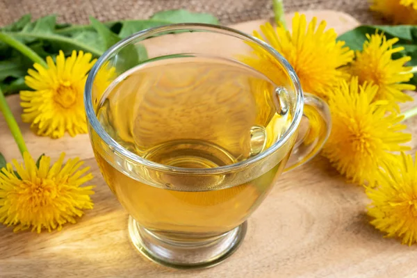 En kop mælkebøtte te med friske blomster - Stock-foto
