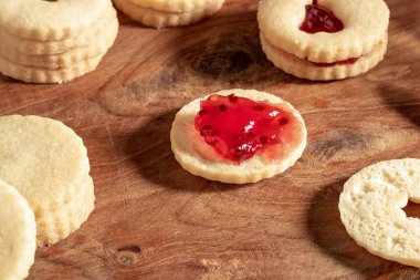 Linzer Noel kurabiyelerini kırmızı frenk üzümü reçeliyle dolduruyorum.